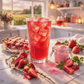 Glass of red iced tea with strawberries and pie on a table with a scenic background