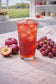 Sherple red plum grape loaded tea in tall glass with ice
