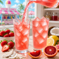 Tiger's Blood loaded tea being poured over ice into a tall glass beside a finished glass of bright pink-red iced tea. Fresh strawberries, blood orange slices, lemon wedges, and coconut pieces surround the drinks on a sunlit kitchen table. A colorful snow cone stand is visible through the window, creating a fun summer refreshment vibe